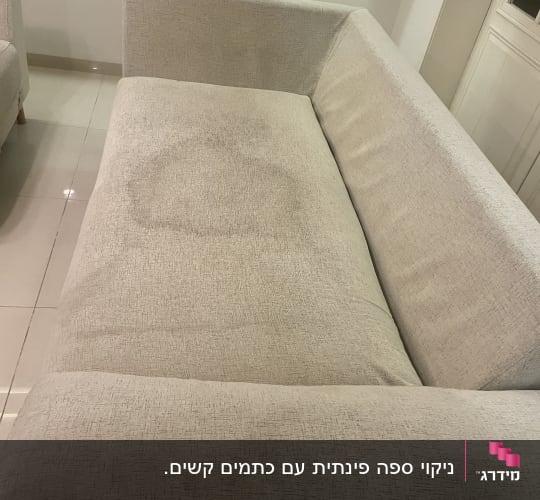 ספה עם כתם על המושב המרכזי